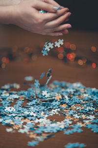 Close-up of hand holding leaves on table