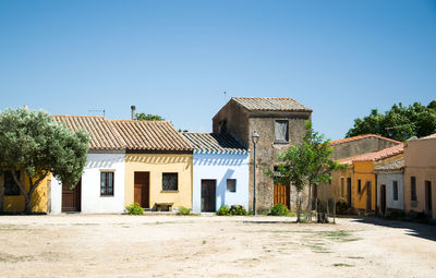 Houses and buildings against clear blue sky