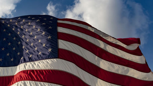 Low angle view of flag against blue sky