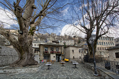 Street amidst buildings and trees against sky