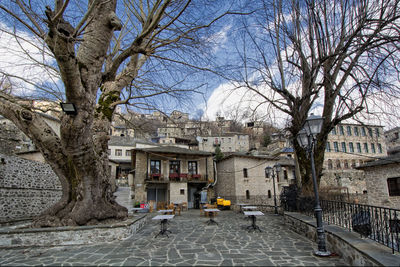 Street amidst buildings and trees against sky