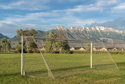 Scenic view of field by mountains against sky