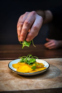 Close-up of hand holding food in plate