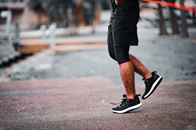 Fitness concept. healthy lifestyle. man in black jumping with skipping rope in the park.