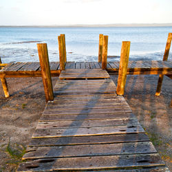 Wooden pier on sea against sky