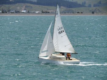 Men sailing sailboat on sea