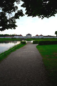 Footpath by lake against sky