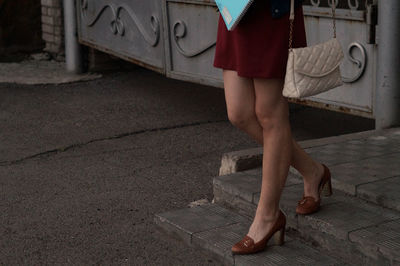 Low section of woman walking on steps