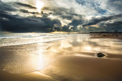 Scenic view of beach against dramatic sky