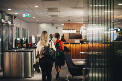 Rear view of female business colleagues walking in lobby at office