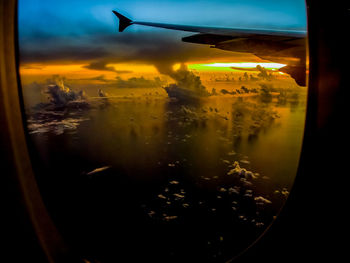 Airplane flying over dramatic sky seen from window