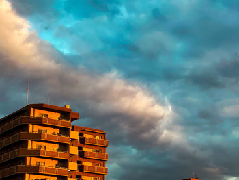 Low angle view of buildings against dramatic sky