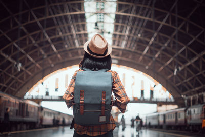Rear view of woman standing against built structure