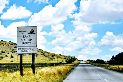 Information sign on road against sky