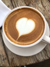 High angle view of coffee cup on wooden table