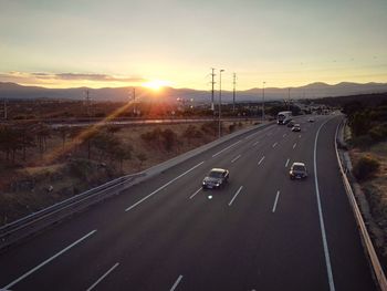 Road passing through sunset