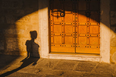 Side view of woman standing against building