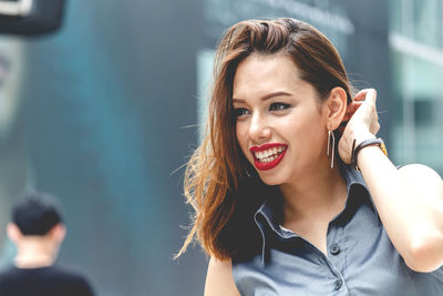 Close-up of happy young woman looking away in city