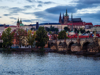 Arch bridge over river against buildings in city