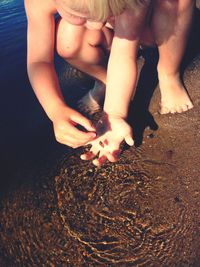 Close-up of girl with hands on beach