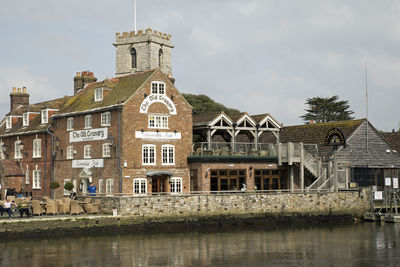 Building by canal against sky