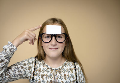 Portrait of young woman wearing sunglasses against black background