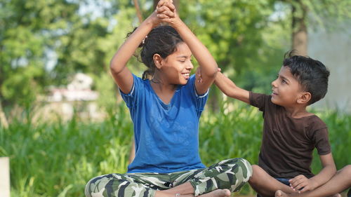 Kids doing yoga pose in the park outdoor. healthy life style concept.