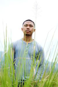 Portrait of young man on field against sky
