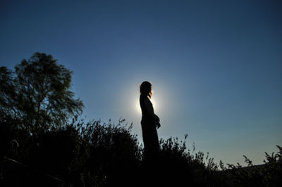 Silhouette woman standing against clear blue sky
