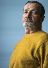 Portrait of senior man against blue background