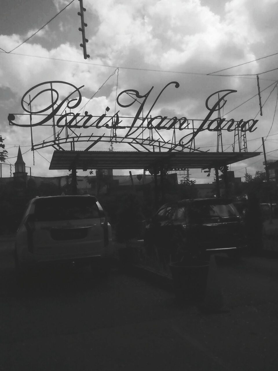 CARS ON CITY STREET AGAINST SKY IN BACKGROUND