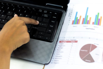 Cropped image of person using laptop on table