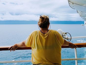 Rear view of woman looking at sea against sky