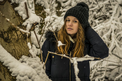 Portrait of young woman with snow during winter