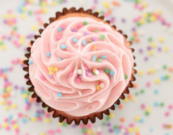 Pink cupcake with sprinkles from a high angle view