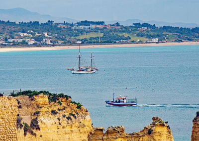 Sailboats sailing in sea against sky