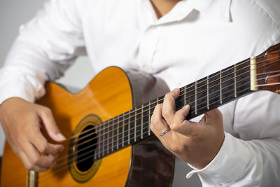 Midsection of man playing guitar