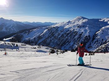 People skiing on snowcapped mountain against sky