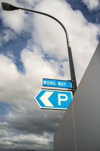 Low angle view of road sign against sky