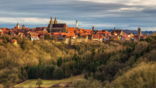 Buildings in town against cloudy sky