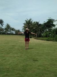 Full length of woman standing on grassy land