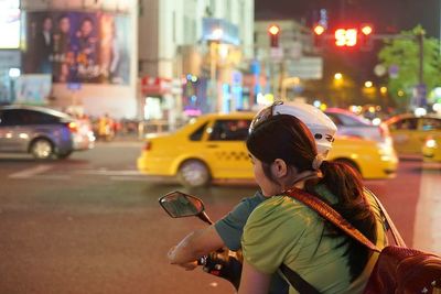 Portrait of woman in illuminated city