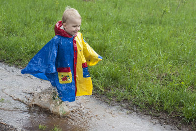 Boy jumping in the puddle
