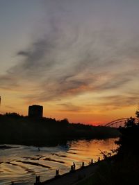 Scenic view of lake against orange sky