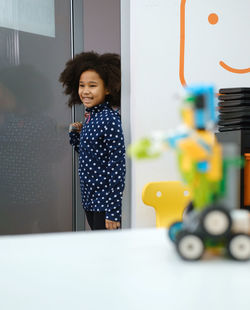 African american school girl entering modern class room door for science and constructing lesson