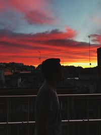 Silhouette of man and tower against sky during sunset