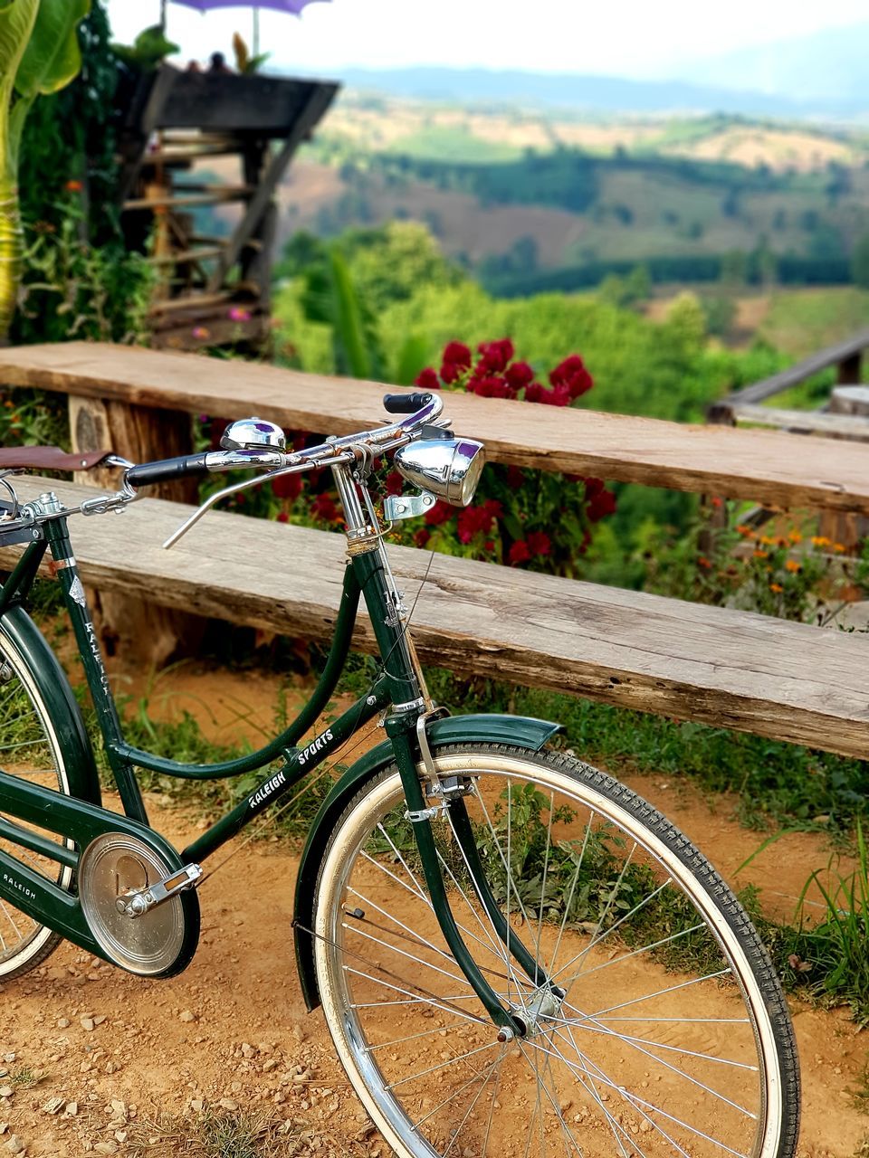 BICYCLE PARKED ON FIELD BY MOUNTAINS