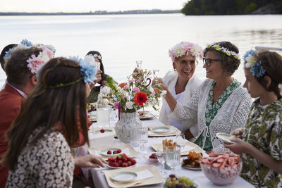 Family having midsummer dinner by lake