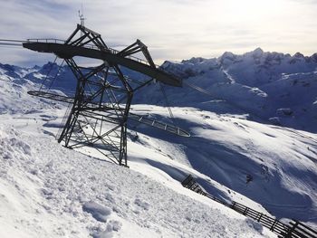 Tower on snowcapped mountain against sky