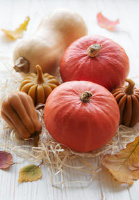 Autumn decorative pumpkins with fall leaves on wooden background. 